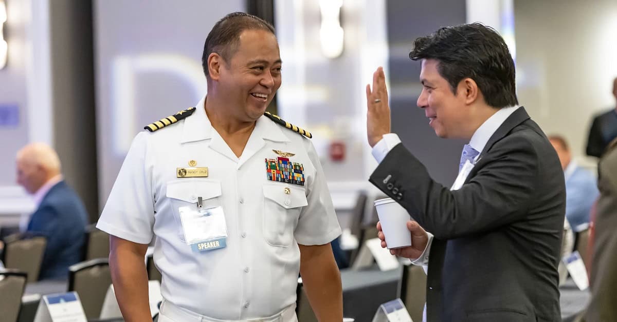 Capt. Randy Cruz, a panelist in the Hybrid Fleet in Production session, networks with an industry guest. Photo: EM Randy Cruz and GovCon professional. The Navy Research Lab captain networked with guests at the 2026 Navy Summit.